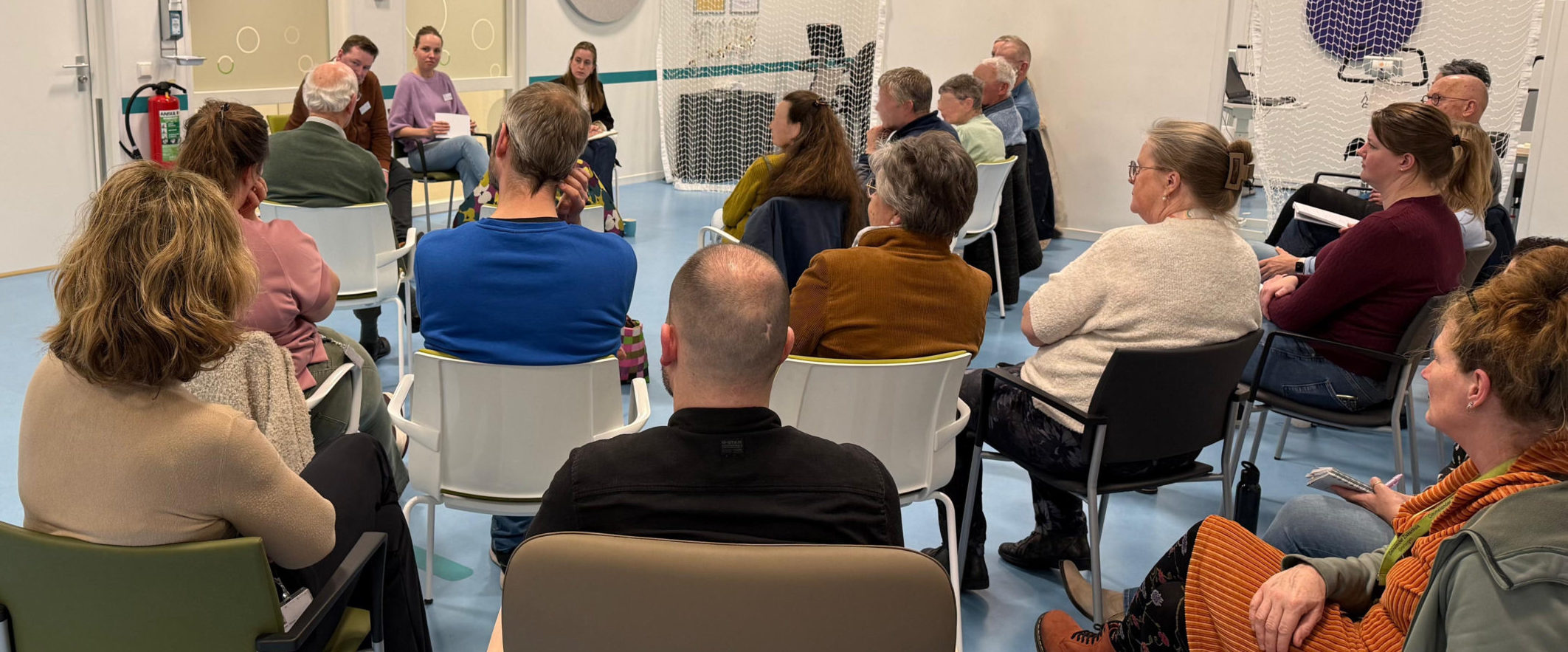 Een groep mensen met elkaar in gesprek